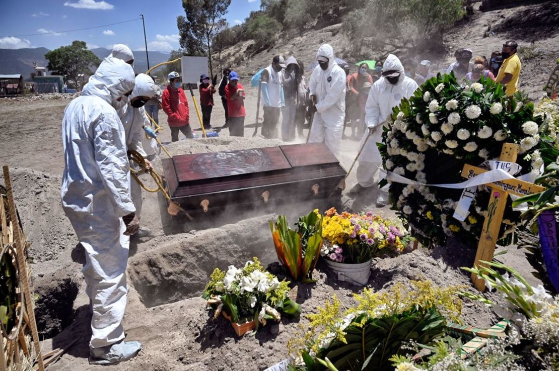 TOPSHOT - Workers bury an alleged victim of Covid-19 at the Municipal Pantheon of Valle de Chalco, State of Mexico on June 4, 2020. (Photo by ALFREDO ESTRELLA / AFP)