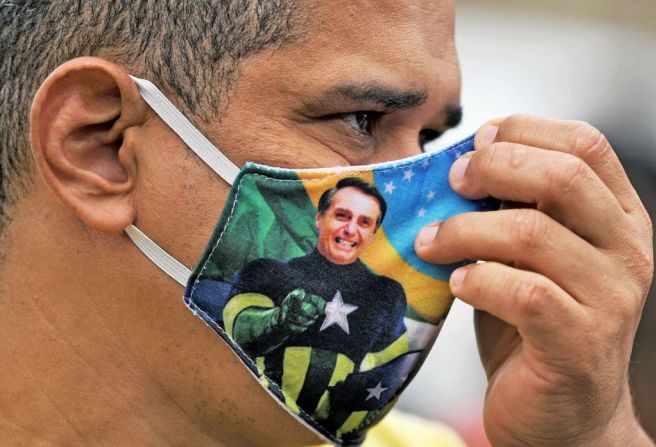 Un partidario del presidente de Brasil, Jair Bolsonaro, usa un tapabocas que muestra al presidente vestido de superhéroe en Río de Janeiro.