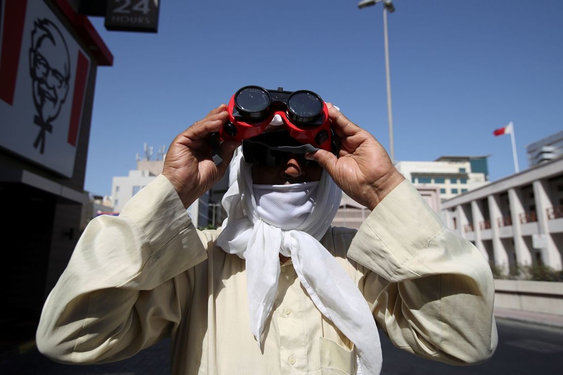 Un hombre usa gafas protectoras especiales para monitorear el eclipse solar anular en Manama, Bahrein.