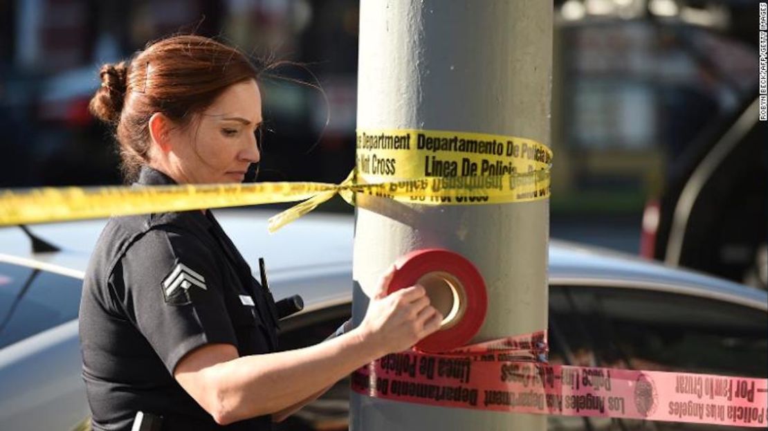 Una agente de policía utiliza cinta  para acordonar un área fuera de un restaurante en Hollywood, California, en enero de 2017.