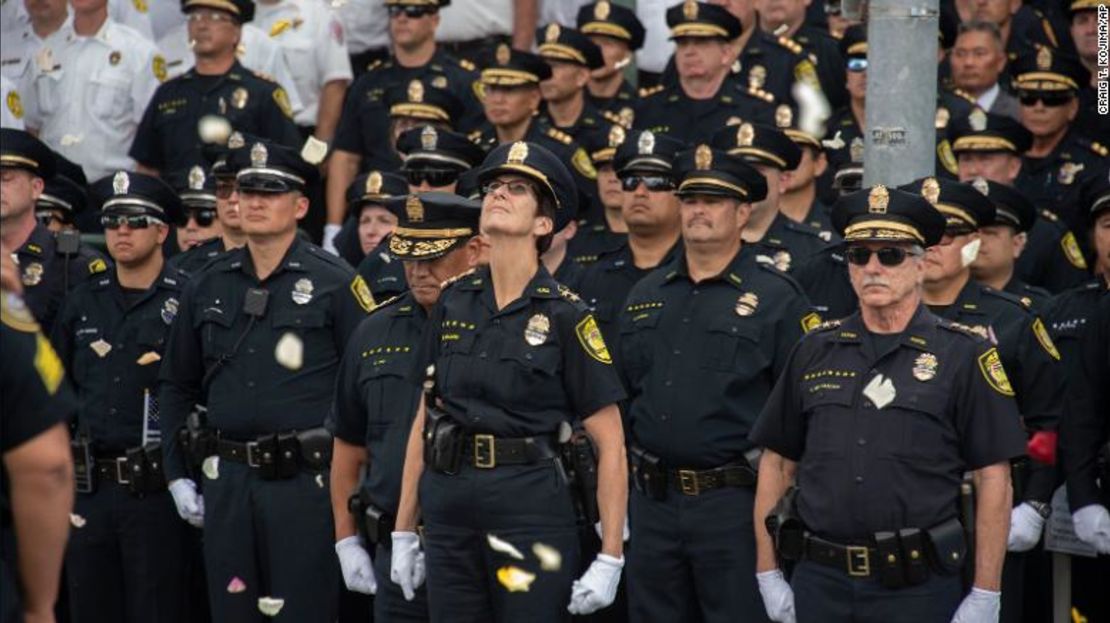 La jefa de policía de Honolulu, Susan Ballard, en el centro, mira hacia arriba mientras el Departamento de Bomberos de Honolulu y los helicópteros la Policía dejan caer flores en una procesión para la agente de policía Tiffany-Victoria Enríquez, el 30 de enero de 2020.