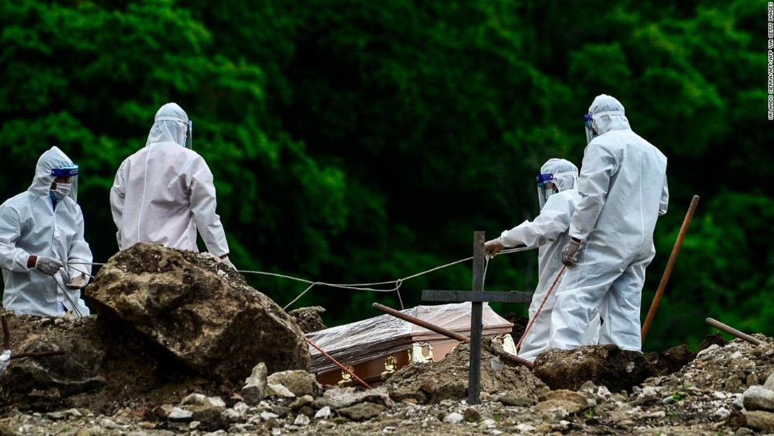 Hombres con equipo de protección entierran a una víctima de coronavirus en un cementerio a 14 km al norte de la capital de Honduras, Tegucigalpa, el 21 de junio de 2020.