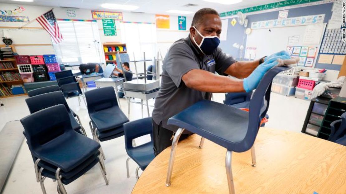 El custodio de las Escuelas Públicas de Des Moines, Tracy Harris, limpia las sillas en un salón de clases en la Escuela Primaria Brubaker.