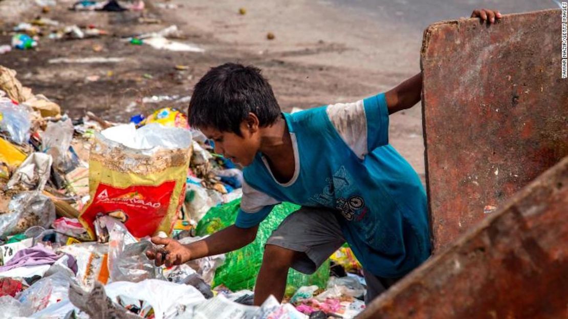 Un niño indio recoge desechos de un vertedero, el 15 de julio de 2020, en Nueva Delhi, India.