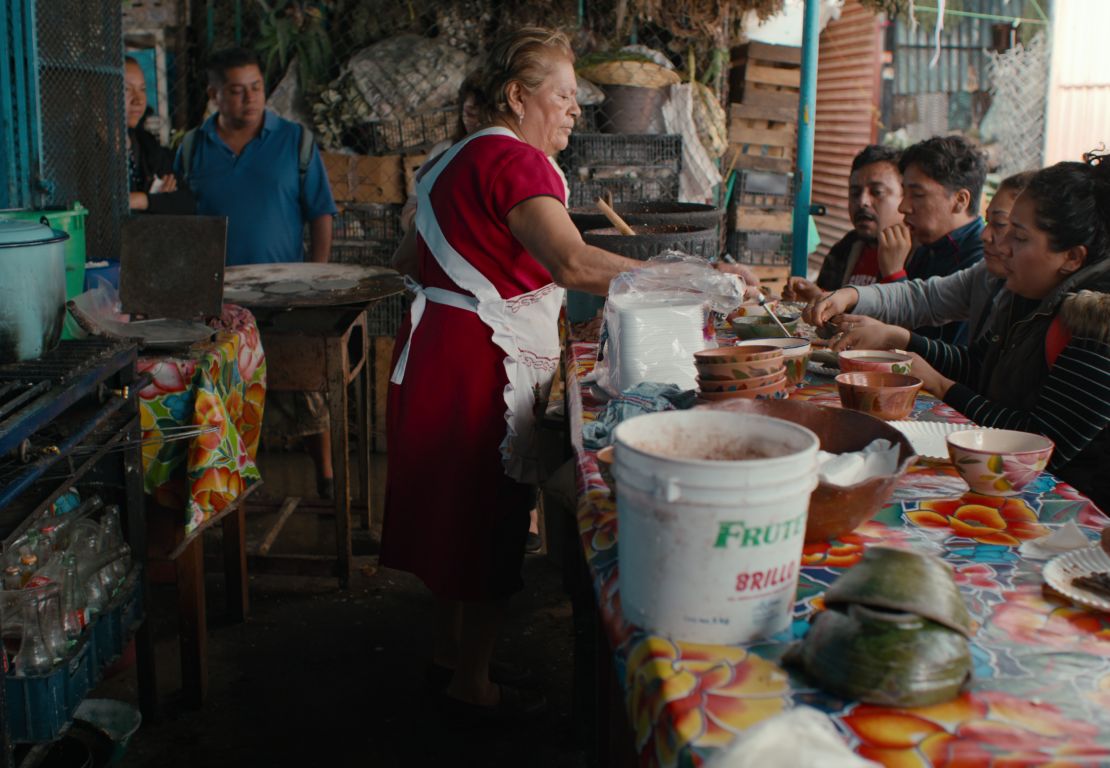 Para quien es fanático del chile, Doña Vale prepara las memelas con chile morita en la Central de Abastos de Oaxaca, México.