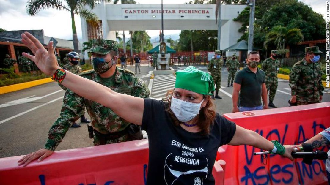 Una mujer usa una mascarilla mientras participa en una protesta el 3 de julio frente a un cuartel del ejército por la presunta violación de niñas indígenas por miembros del Ejército colombiano.