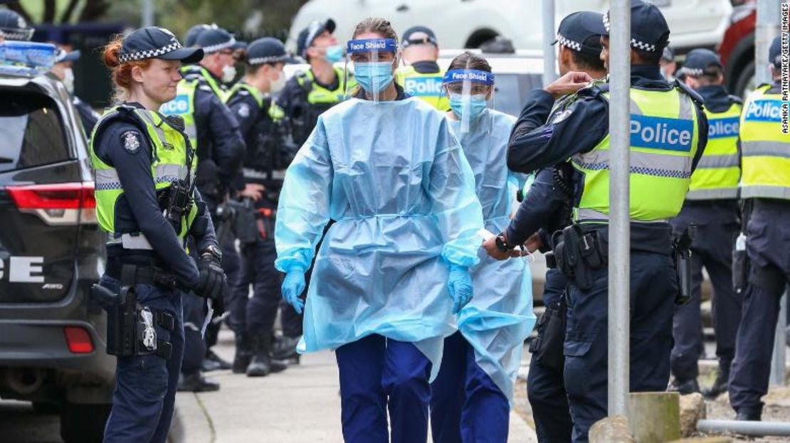 Personal médico con equipos de protección personal ingresa a los pisos de viviendas públicas de Flemington en Melbourne, Australia, después de que 9 complejos del lugar fueran confinados.