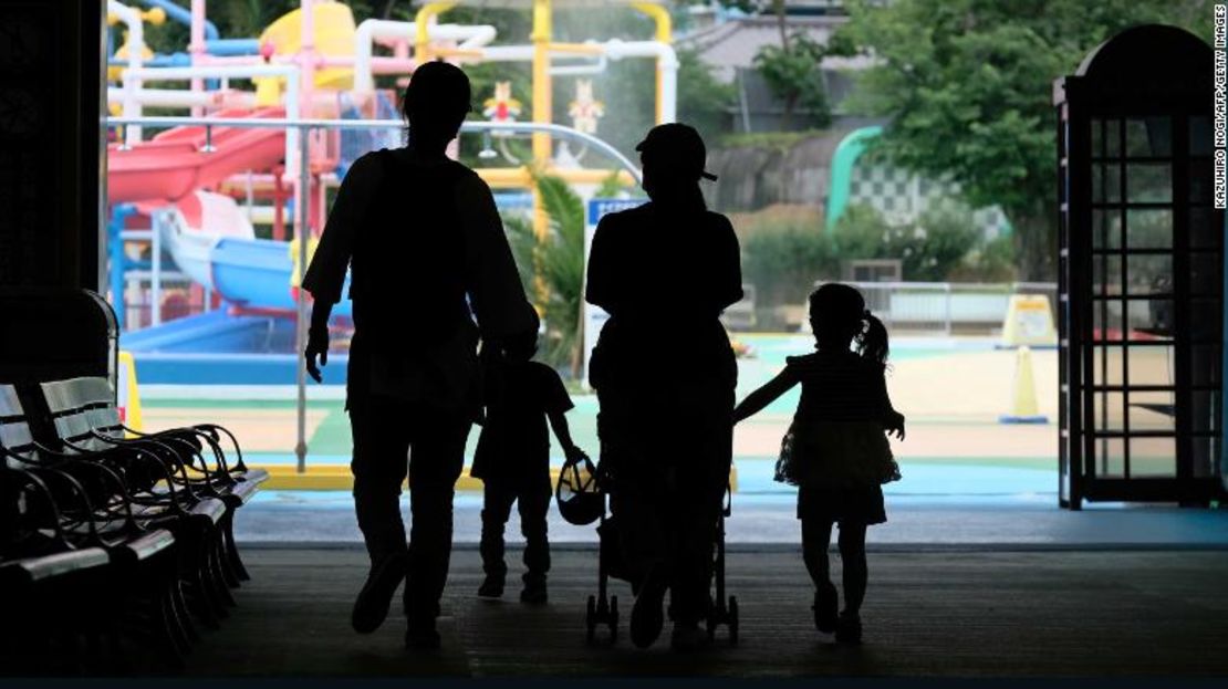 Padres y niños ingresan a una piscina abierta a un número limitado de visitantes como medida preventiva contra el coronavirus en el parque de atracciones Toshimaen de Tokio el 13 de julio.