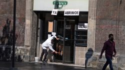 A worker cleans the entrance of a restaurant in the historic centre of Mexico City on July 22, 2020, amid the COVID- 19 novel coronavirus pandemic. - The novel coronavirus has killed at least 616,965 people since the outbreak emerged in China last December, according to a tally from official sources compiled by AFP at 1100 GMT on Wednesday. Mexico is currently the fourth worst-hit country in the world with 40,400 deaths from 356,255 cases. (Photo by CLAUDIO CRUZ / AFP)