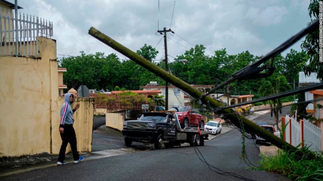 Un hombre dirige una grúa debajo de un poste de electricidad caído, luego de que la tormenta tropical Isaías afectara el área en Mayagüez, Puerto Rico, este jueves.