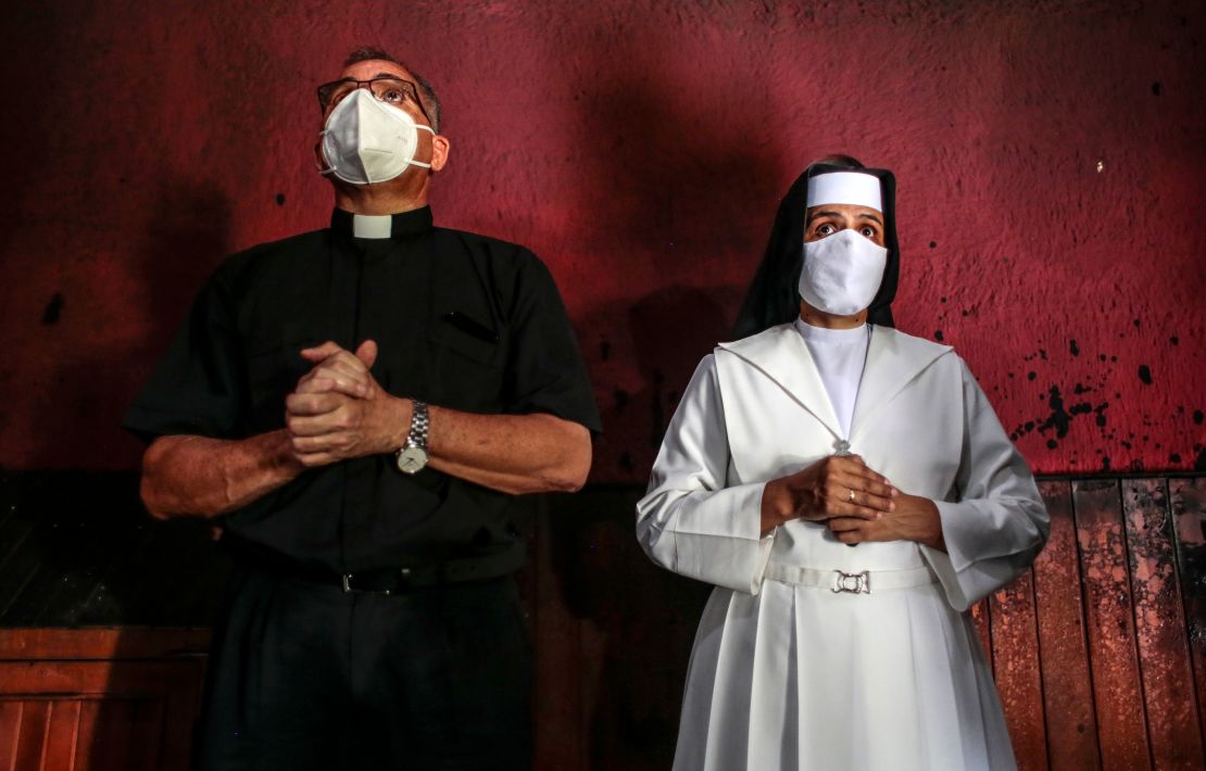 Un sacerdote y una monja miran la imagen de la Sangre de Cristo después de que un incendio la quemara en la Catedral de Managua el 31 de julio de 2020 (Oswaldo Rivas/POOL/AFP/Getty Images).