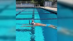 CNNE 869817 - nadadora olimpica cruza piscina con un vaso en la cabeza