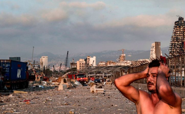 Un hombre mira con asombro la escena caótica tras la explosión en Beirut.