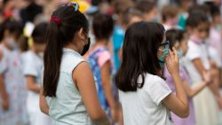 BERLIN, GERMANY - AUGUST 10: Children wearing protective face masks arrive for the first day of classes of the new school year at the GuthsMuths elementary school during the coronavirus pandemic on August 10, 2020 in Berlin, Germany. Classes at schools across Germany are beginning this month with face mask requirements varying by state. Coronavirus infection rates are climbing again in Germany, from an average of 400 new cases per day about two weeks ago to over 1,100 yesterday, according to the Robert Koch Institute.