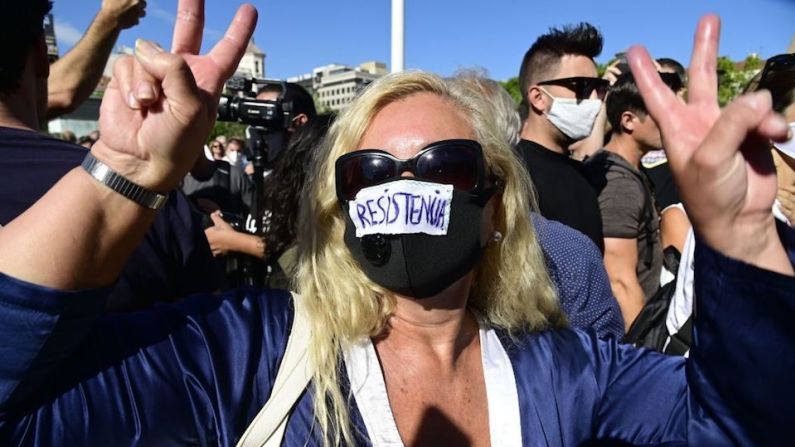 Manifestantes que sí llevaban mascarillas colocaron mensajes de protesta sobre su cobertura facial.