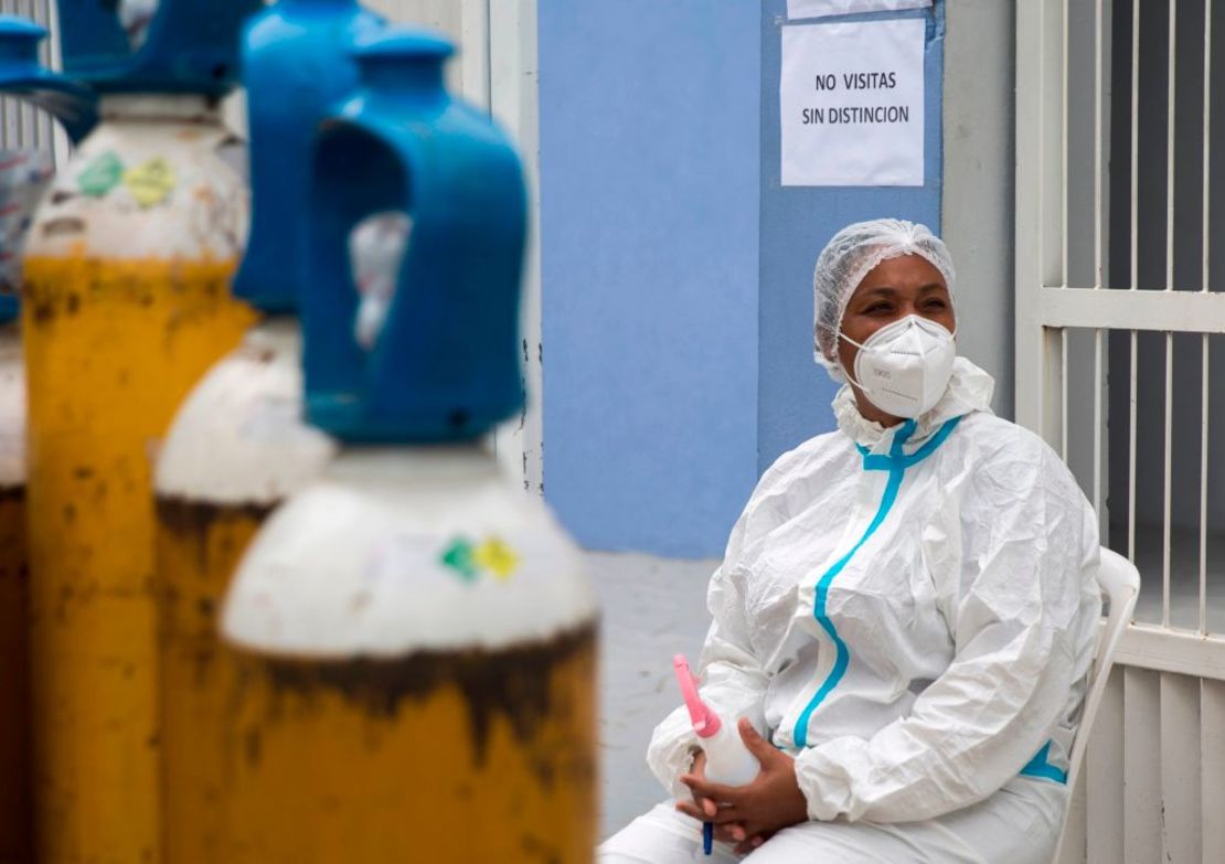 Una trabajadora médica frente a cilindros de oxígeno en la entrada del área de covid-19 en el Hospital Moscoso Puello en Santo Domingo.