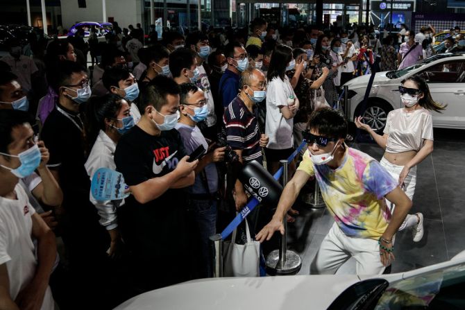 Bailarines realizan una presentación con mascarillas en el stand Volkswagen en el 18 Show Automotriz Internacional de China Central en Wuhan el 13 de agosto.