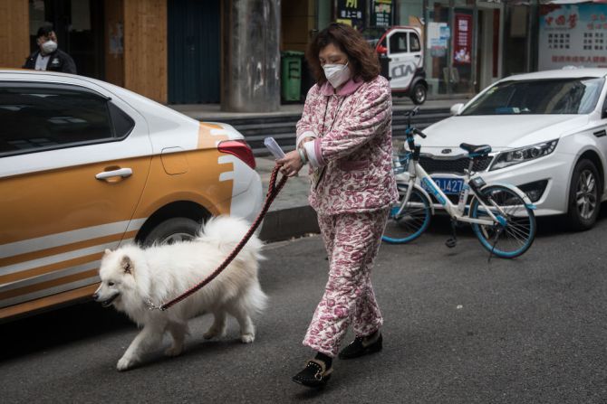 Una mujer pasea a su perro en Wuhan el 11 de abril, días después de que el Gobierno comenzó a levantar restricciones de viaje en la ciudad.