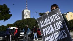 A woman holds a placard that reads "food for the soup kitchens" while marching with piqueteros and social organizations to Casa Rosada government palace to demand  more aid to survive the crisis caused during the lockdown imposed by the government against the spread of the new coronavirus, COVID-19, in Buenos Aires, on June 11, 2020. (Photo by JUAN MABROMATA / AFP)