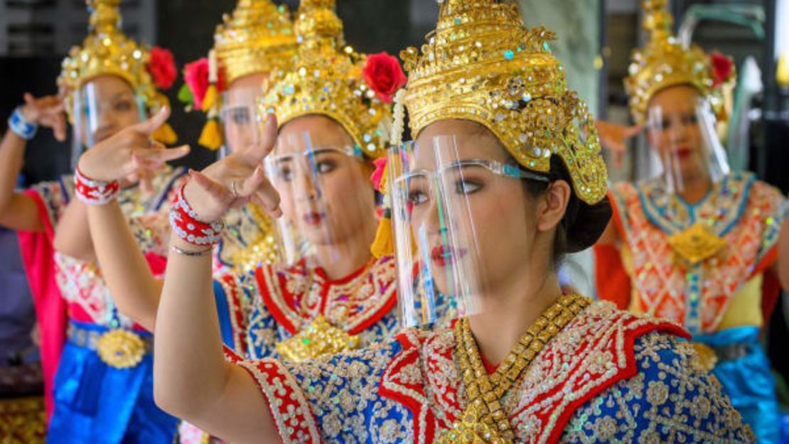 Bailarinas tradicionales tailandesas usan máscaras protectoras durante una presentación en el Erawan Shrine de Bangkok.