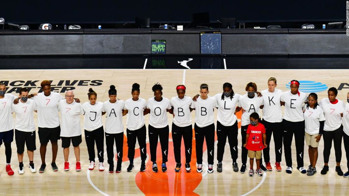 Después del anuncio de la WNBA del aplazamiento de partidos, los integrantes del Washington Mystics llevan camisetas blancas con siete balas en la espalda en protesta por el tiroteo de Jacob Blake.