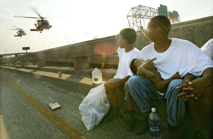 Eugene Green sostiene a su bebé, Eugene Jr., mientras esperan ser transportados por vía aérea desde un lugar elevado en una autopista en Nueva Orleans el 4 de septiembre de 2005. Mario Tama / Getty Images