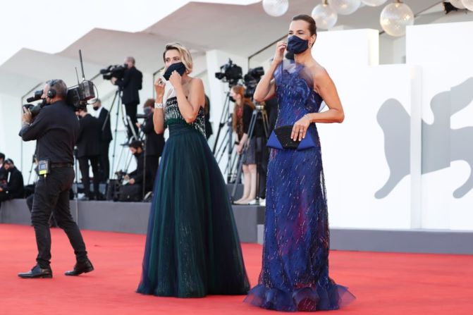 Las actrices Anna Foglietta y Roberta Armani llegan a la ceremonia de apertura con mascarillas de tela que hacen juego con sus vestidos en verde oscuro y azul vivo. Este año, las mascarillas son un elemento común en la alfombra roja.