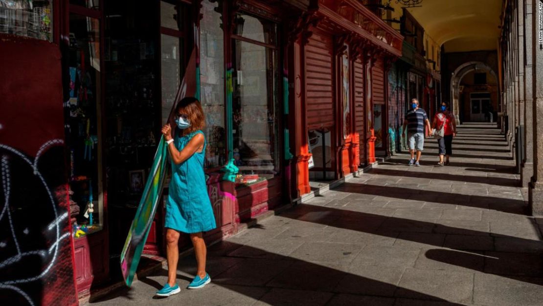 Una mujer con una mascarilla abre una tienda en el centro de Madrid, España, el 3 de septiembre.