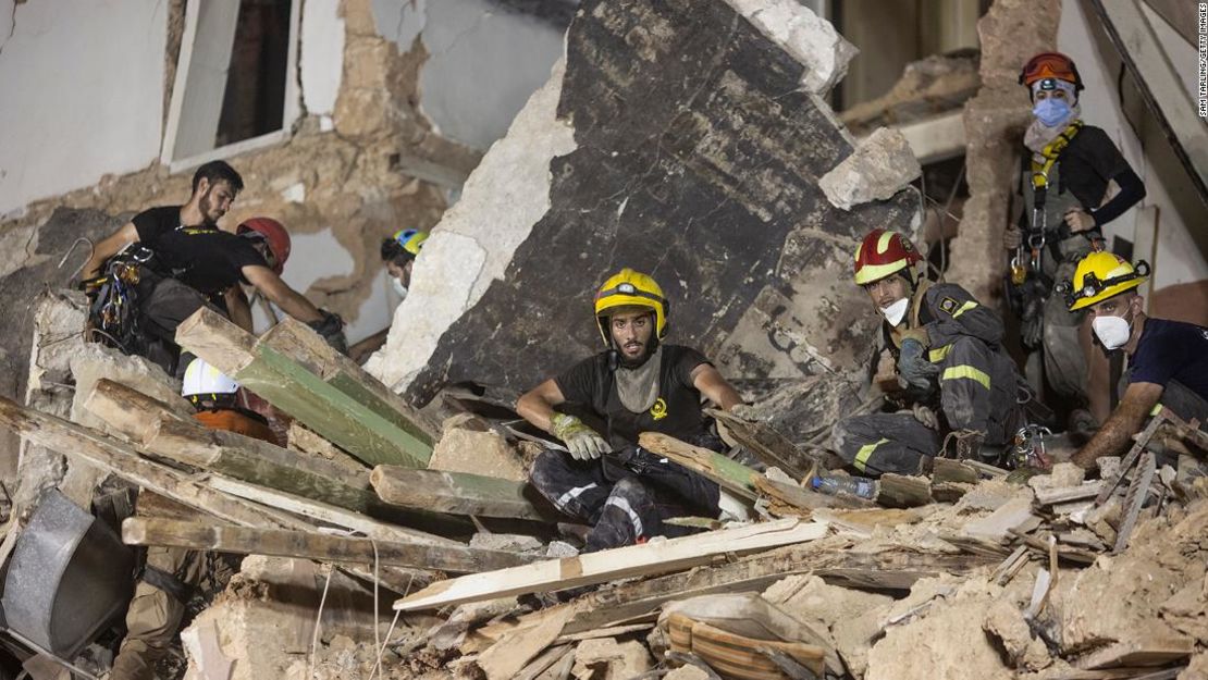 Los equipos de rescate limpian los escombros de un edificio destruido con el objetivo de encontrar un posible superviviente tras la explosión de Beirut.