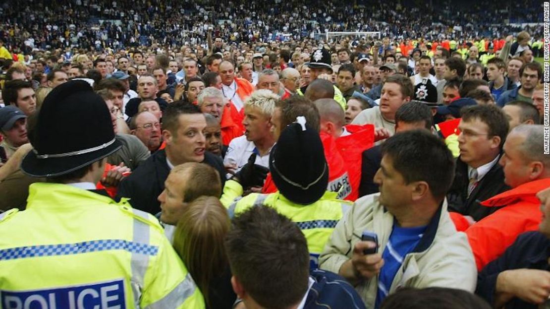 El héroe local y delantero del Leeds United, Alan Smith (centro), es acosado mientras miles invaden el campo de Elland Road tras el descenso del club en 2004.