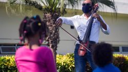 Dominican cellist of the National Symphony Orchestra, Pablo Polanco, plays his electric cello at the gardens of the Hugo Mendoza pediatric hospital in Santo Domingo, on September 8, 2020 as part of a personal initiative to share his music especially with those affected by the new Covid-19 coronavirus. (Photo by Erika SANTELICES / AFP)