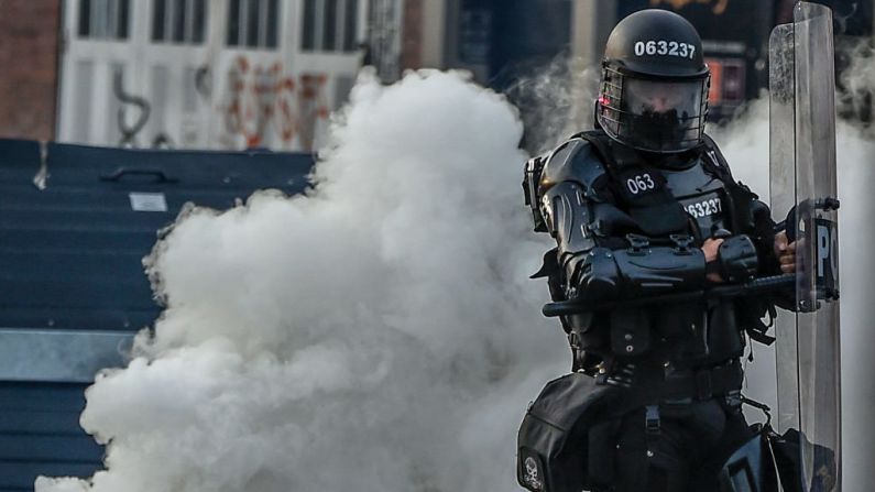 Un policía antimotines frente a una nube de humo durante las protestas en Bogotá.