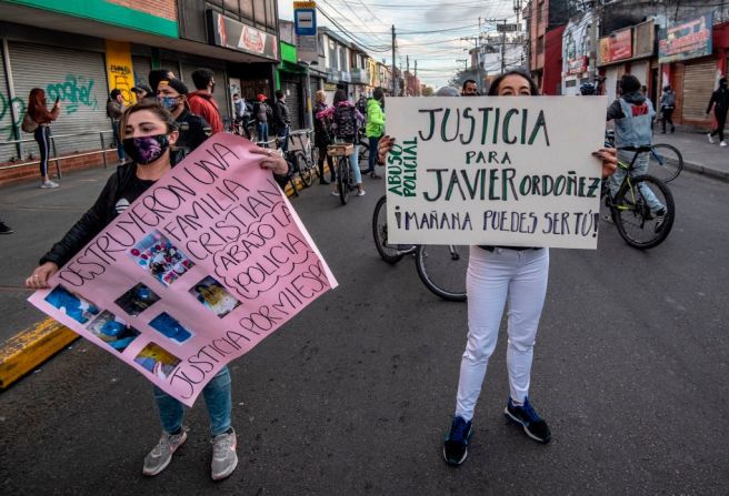 Gente en Bogotá protesta con pancartas en contra del supuesto abuso policial y piden justicia.