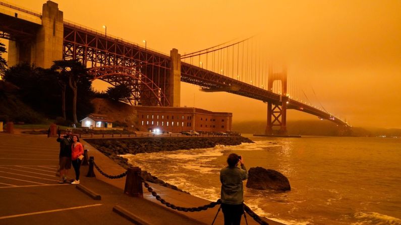 Personas en San Francisco toman fotografías del puente Golden Gate, afectado por el humo de los incendios forestales cercanos el miércoles 9 de septiembre. Eric Risberg / AP