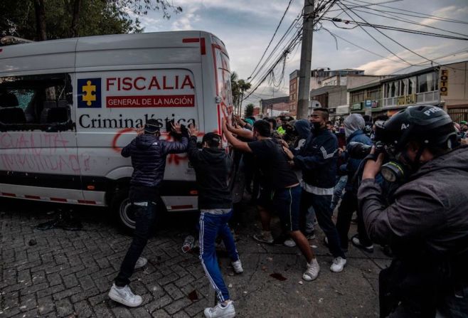 Manifestantes empujan y destruyen una camioneta de la Fiscalía General durante la protesta.