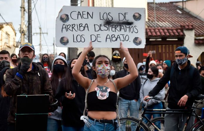 "Caen los de arriba, despertamos los de abajo", dice pancarta de manifestante en Bogotá.