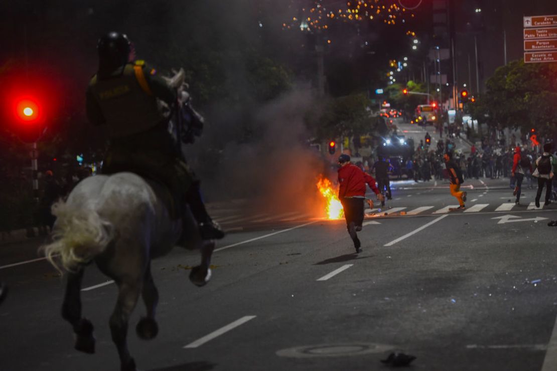 Manifestantes huyen mientras los persiguen los Carabineros durante una protesta en Medellín, Colombia.