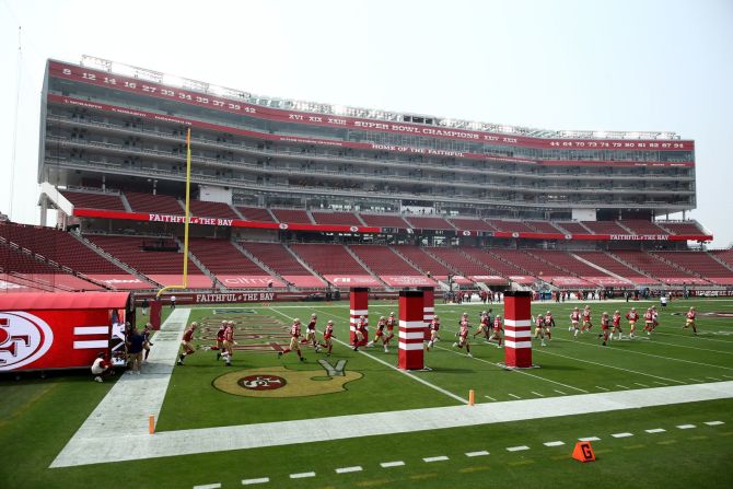 Los San Francisco 49ers corren hacia el campo antes de su juego contra los Arizona Cardinals el domingo. Ezra Shaw / Getty Images