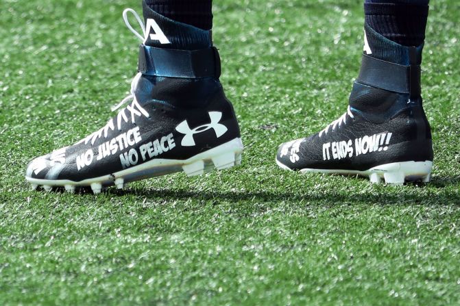 Detalle de las zapatillas que usa el mariscal de campo de los New England Patriots, Cam Newton, antes de un partido entre los Patriots y los Miami Dolphins en el Gillette Stadium el domingo. Las zapatillas incluían las frases "Digan sus nombres", "Esto termina ahora" y "Sin justicia, no hay paz", en letras blancas, así como "7 tiros" en letras rojas, la cantidad de disparos que Jacob Blake, de 29 años, recibió en la espalda de la policía en Kenosha, Wisconsin, el 23 de agosto. Maddie Meyer / Getty Images