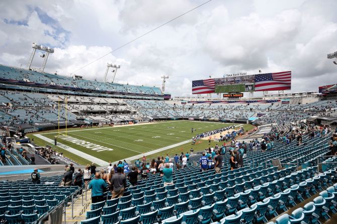 Los fanáticos se levantan para el Himno Nacional antes de un juego entre los Jacksonville Jaguars y los Indianapolis Colts el domingo. Jacksonville fue uno de los pocos equipos que tuvo fanáticos en el estadio. Stephen B. Morton / AP