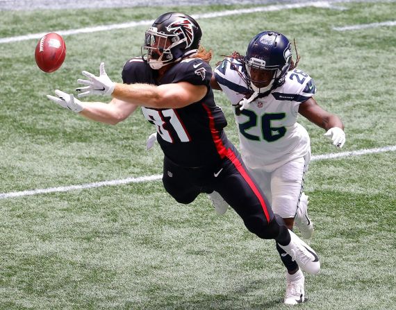 Hayden Hurst, de los Atlanta Falcons, realiza una recepción mientras es custodiado por Shaquill Griffin de los Seattle Seahawks en el Mercedes-Benz Stadium el domingo. Kevin C. Cox / Getty Images