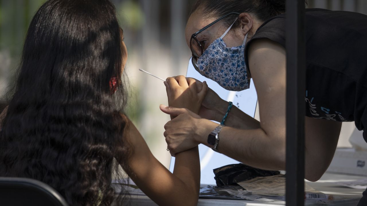 LONDON, ENGLAND - SEPTEMBER 15: A woman administers a swab test to a young girl at a Covid Test site in South London on September 15, 2020 in Greater London, England. The site saw a steady stream of drive in traffic, but only a small handful of walk-ins over the course of the first hour of opening. The Department Of Health has appealed to Britain's biomedical sector for 400 further laboratory technicians as the nation's return to school increases demand for Covid-19 tests.