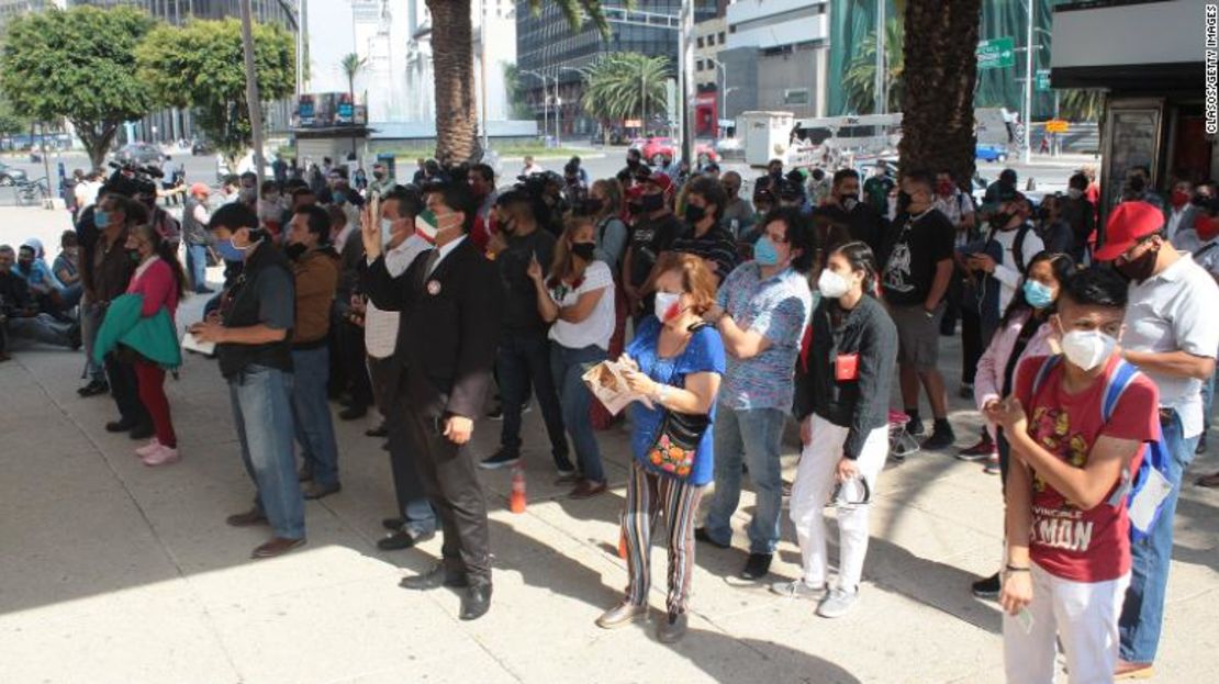 Varias personas observan la rifa a través de una pantalla exterior en el edificio de la Lotería Nacional el 15 de septiembre de 2020, en Ciudad de México.