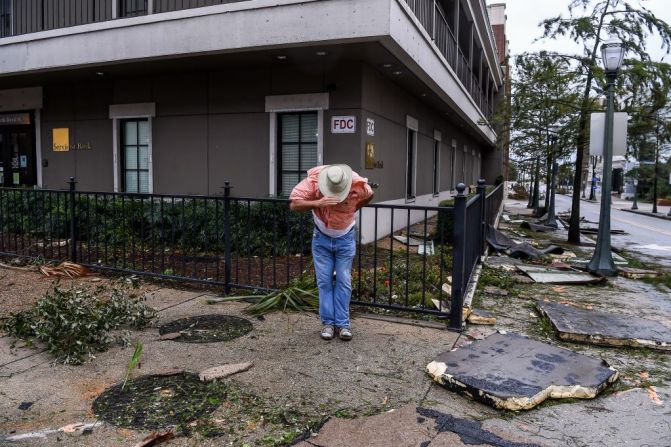 Un hombre intenta salvar su sombrero en medio de la destrucción del fuerte viento provocado por el huracán Sally, ahora tormenta tropical, en Mobile, Alabama el 16 de septiembre de 2020.