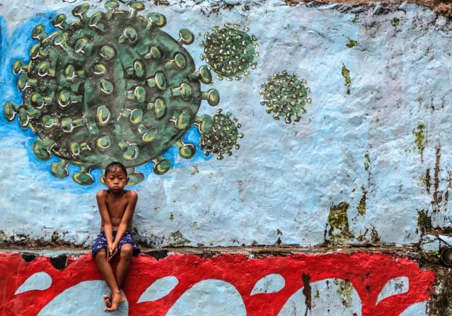 Un niño sentado frente a un mural en Bogor, Java Occidental.