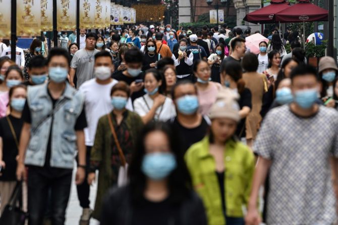 Peatones usan mascarillas en Wuhan, China, epicentro original de la pandemia de coronavirus.