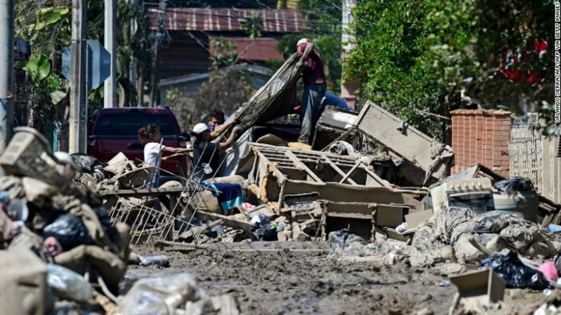 Personas tratan de recuperar sus pertenencias en medio del barro tras el paso del huracán Eta ,mientras se preparan para evacuar el barrio de Omonita en El Progreso, departamento de Yoro, Honduras.