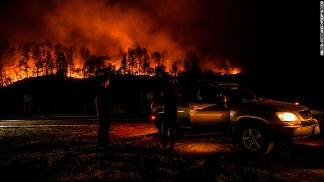 Personas se detienen al costado de una carretera para observar cómo el incendio Glass arde sobre una ladera en las afueras de Calistoga, en la noche de este lunes.