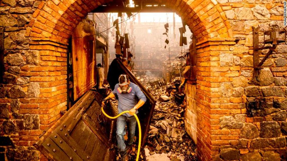 El trabajador de la bodega de vinos José Juan Pérez apaga llamas en Castello di Amorosa, en las afueras de Calistoga el lunes.