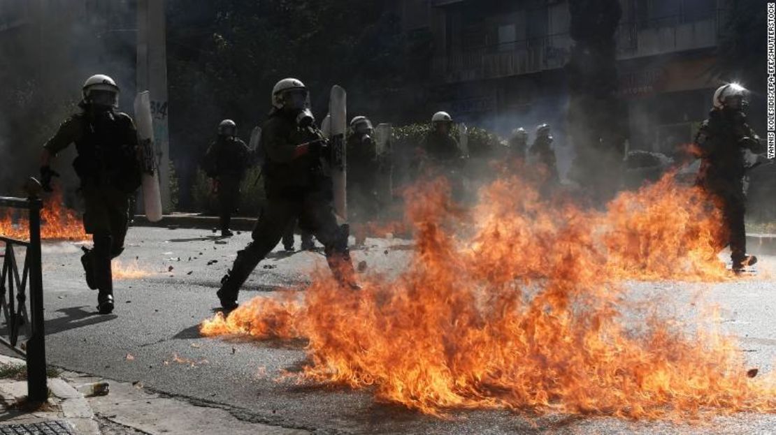 Policías antidisturbios intentan evitar las llamas de una bomba de gasolina lanzada por manifestantes el miércoles.